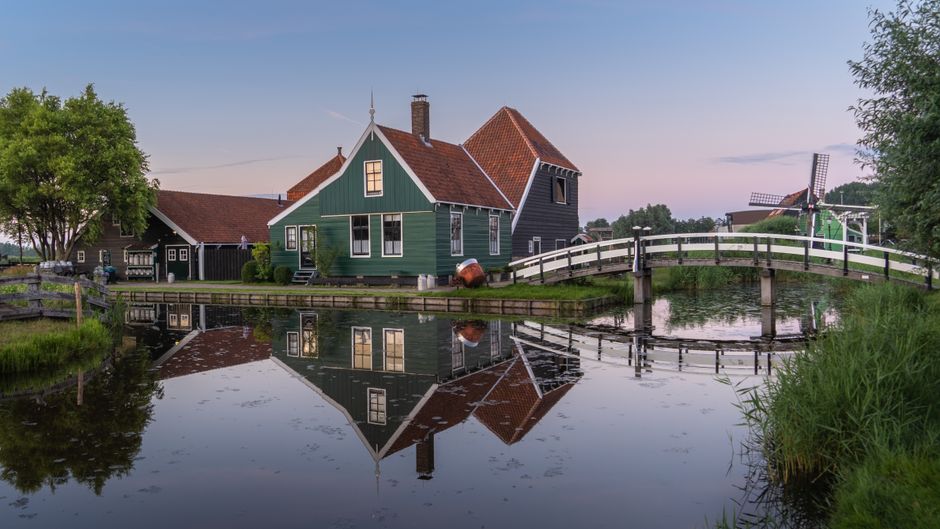 Scenic view of a traditional Dutch house with a reflection on a canal in Zaandam, Netherlands.