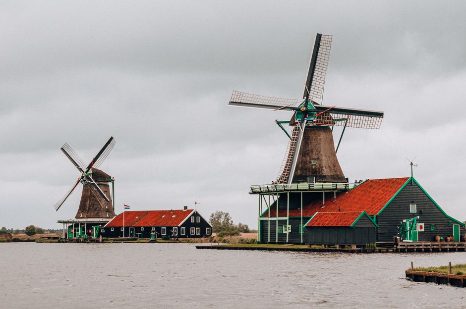 Scenic view of historical windmills by the river in Kinderdijk, Netherlands.